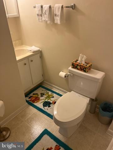 bathroom featuring toilet, baseboards, and vanity