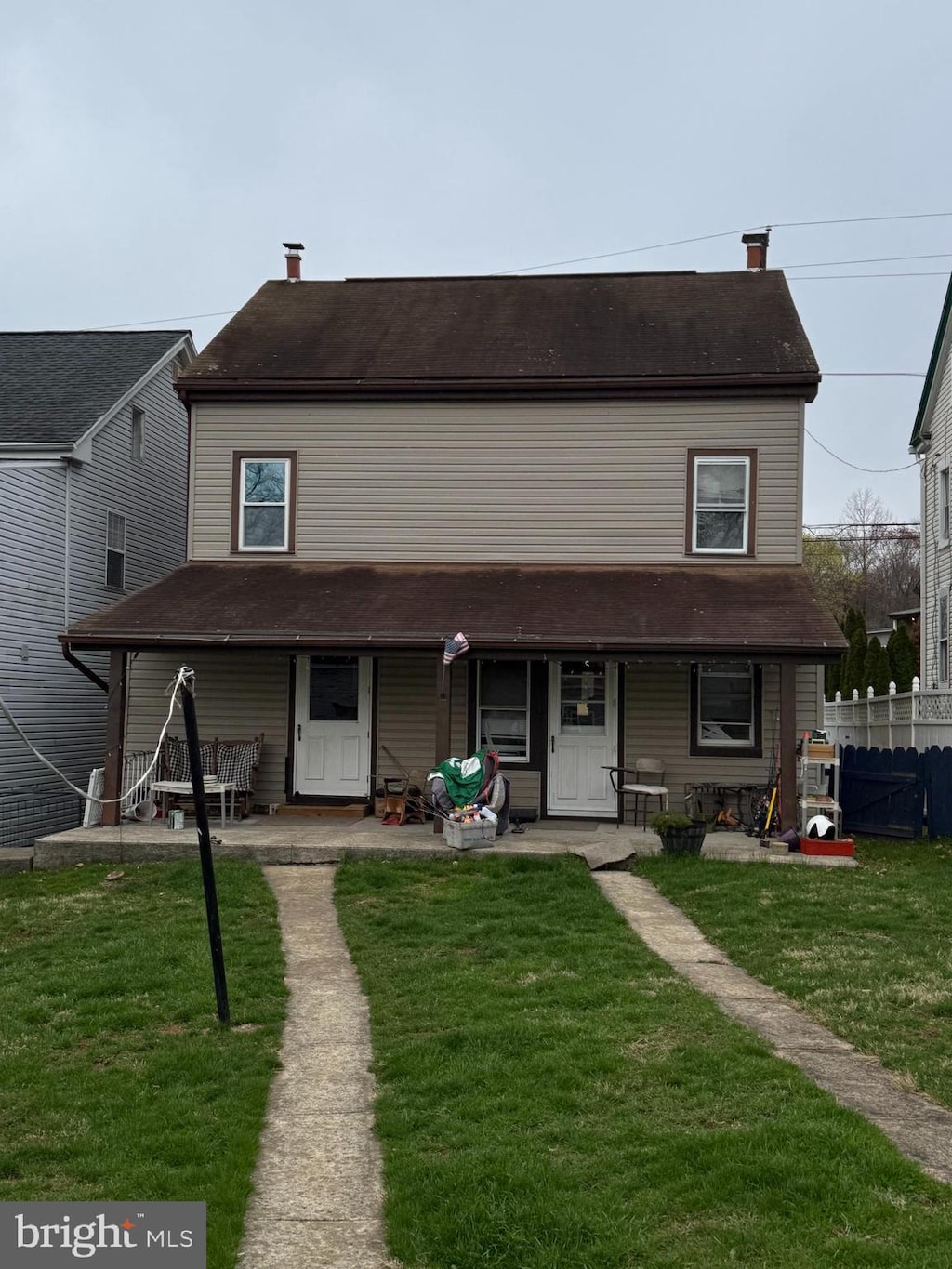 view of front of property featuring fence, a porch, and a front lawn
