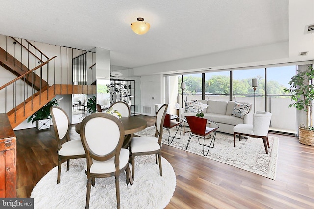 dining room with stairway, wood finished floors, and visible vents