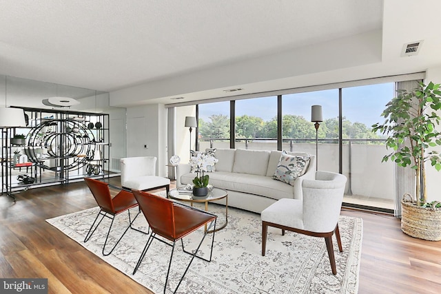 living area featuring visible vents and wood finished floors