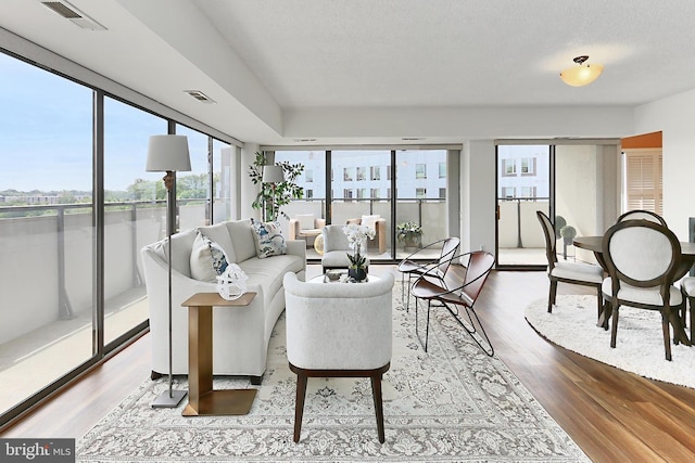 living area with visible vents and wood finished floors