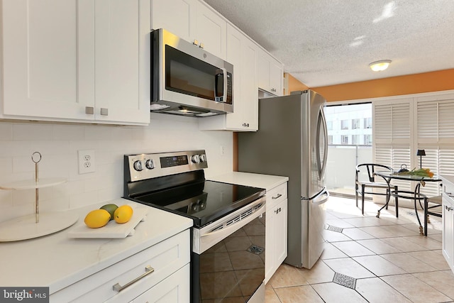 kitchen featuring white cabinetry, a textured ceiling, appliances with stainless steel finishes, and tasteful backsplash