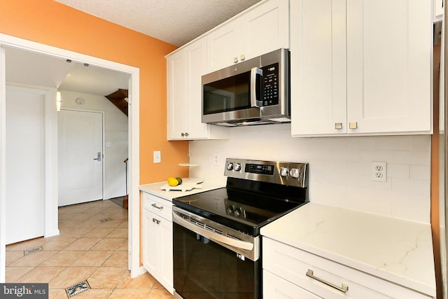 kitchen featuring light countertops, light tile patterned floors, white cabinets, and stainless steel appliances