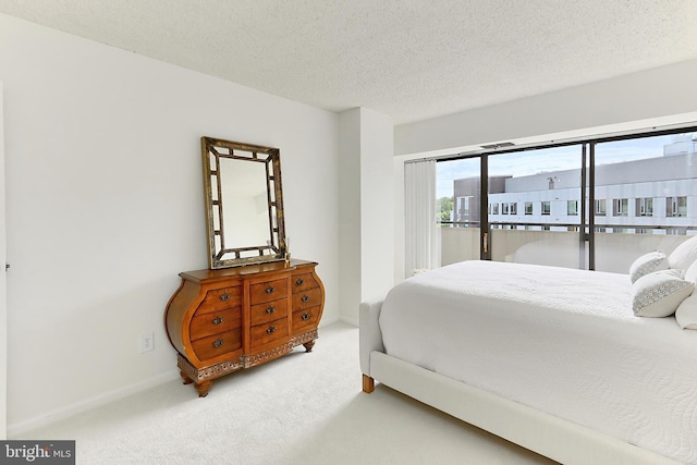 bedroom featuring access to outside, a textured ceiling, carpet, and baseboards