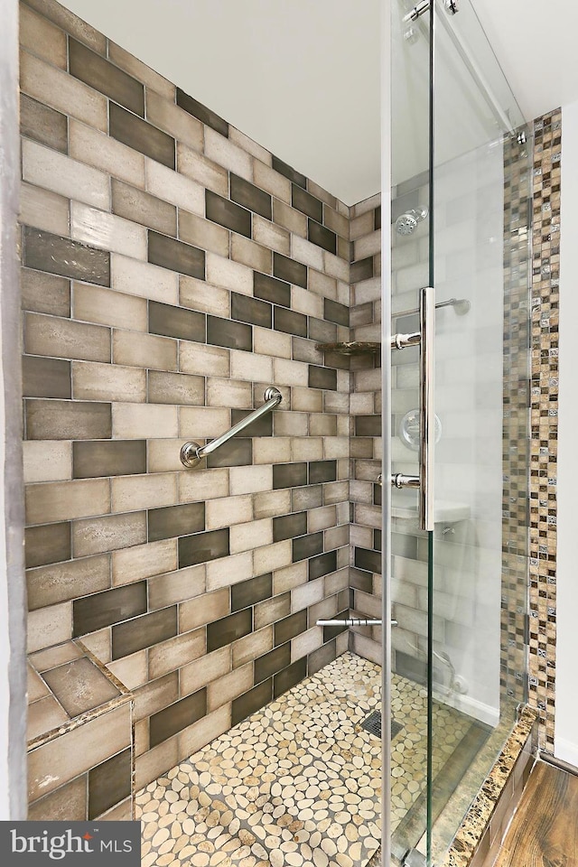 bathroom featuring a tile shower and wood finished floors