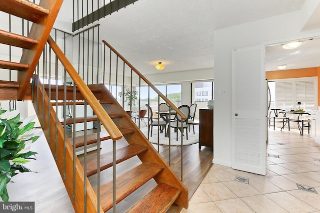 staircase featuring tile patterned floors and baseboards