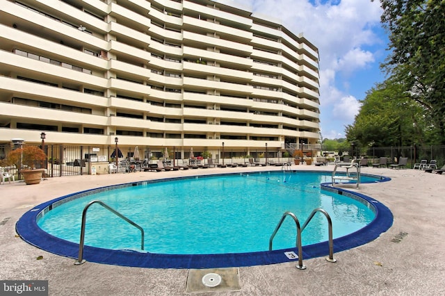 community pool featuring a patio and fence