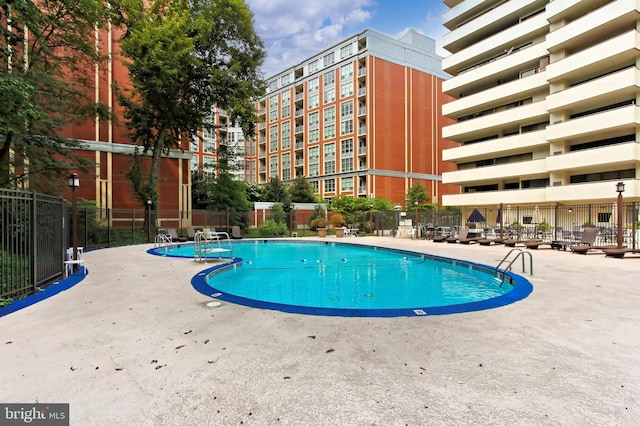 community pool featuring a patio and fence