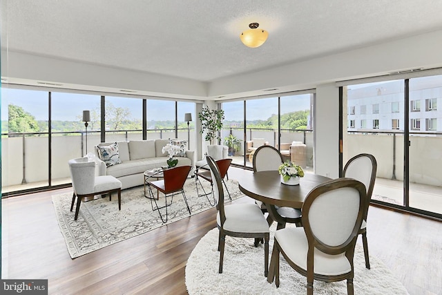 dining space with a textured ceiling and wood finished floors