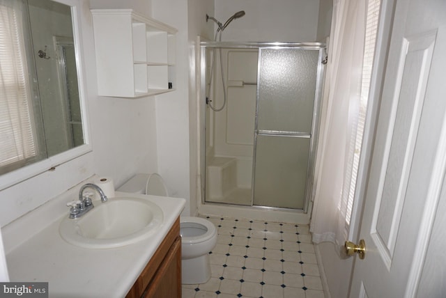 bathroom with vanity, a stall shower, and toilet
