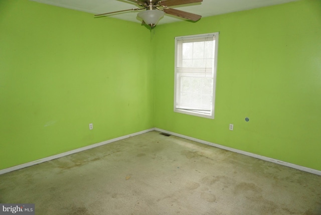 spare room featuring baseboards, ceiling fan, carpet floors, and visible vents