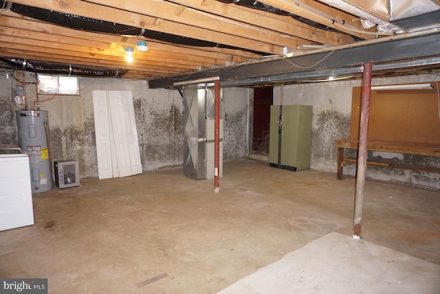 unfinished below grade area with heating unit, washer / clothes dryer, and electric water heater