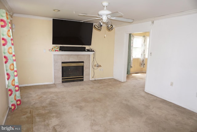 unfurnished living room featuring crown molding, a ceiling fan, carpet floors, and a tiled fireplace