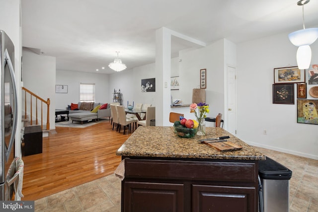 kitchen featuring an inviting chandelier, stainless steel fridge, dark brown cabinets, and decorative light fixtures