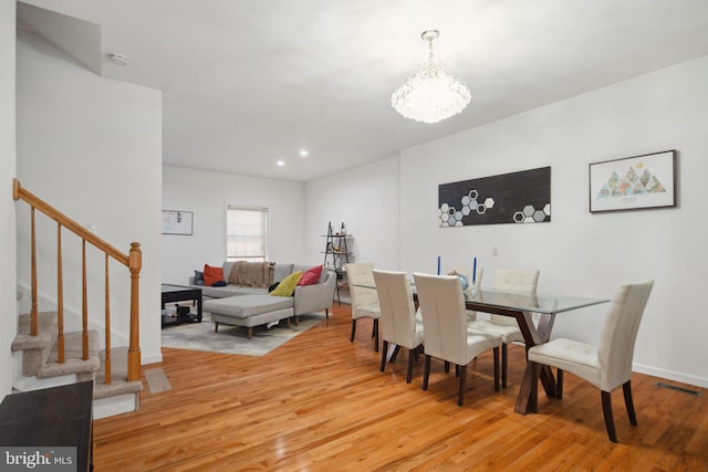 dining room featuring visible vents, wood finished floors, stairway, a notable chandelier, and recessed lighting
