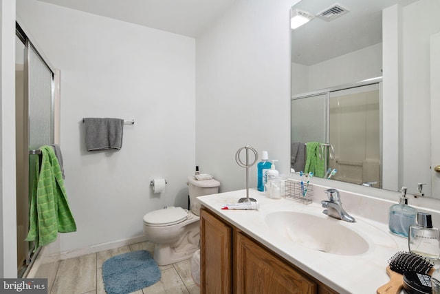 bathroom featuring visible vents, a shower stall, vanity, baseboards, and toilet