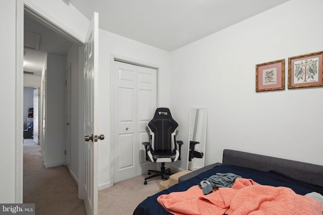 bedroom with baseboards, a closet, and light colored carpet