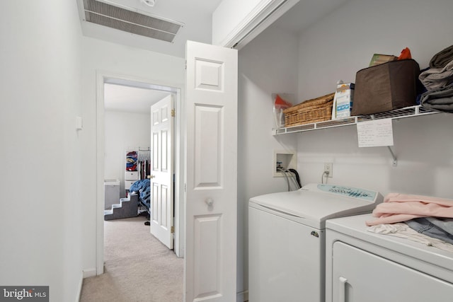 clothes washing area featuring washing machine and clothes dryer, laundry area, light colored carpet, and visible vents