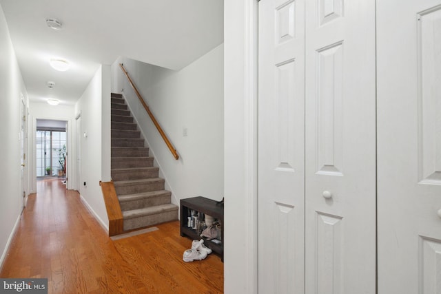 staircase with baseboards and wood finished floors