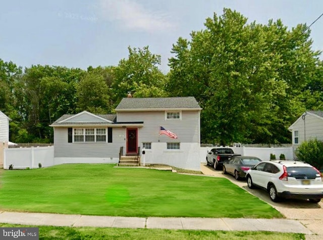 tri-level home with fence and a front lawn