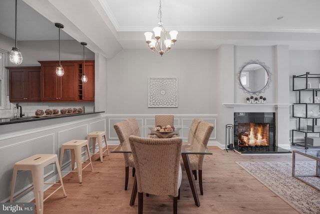 903 R St NW Unit 1, Washington, DC 20001 - dining area featuring a lit fireplace, a notable chandelier, ornamental molding, and light wood-style flooring