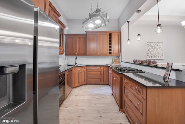 903 R St NW Unit 1, Washington, DC 20001 - kitchen featuring decorative backsplash, brown cabinets, a sink, stainless steel appliances, and light wood-style flooring