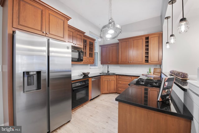 903 R St NW Unit 1, Washington, DC 20001 - kitchen featuring a sink, light wood-style floors, brown cabinetry, tasteful backsplash, and black appliances