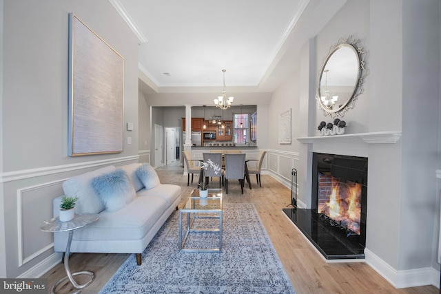 903 R St NW Unit 1, Washington, DC 20001 - living room featuring crown molding, a warm lit fireplace, a notable chandelier, and light wood-style floors