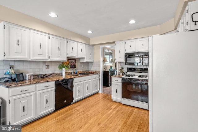 22 Cochise Cir, Medford Lakes, NJ 08055 - kitchen featuring white cabinets, a sink, light wood-style floors, dark stone countertops, and black appliances