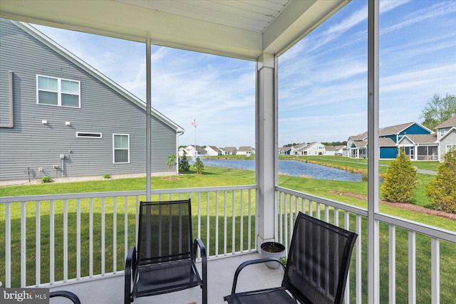sunroom with a water view and a residential view