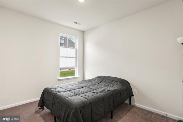 carpeted bedroom featuring baseboards, multiple windows, and visible vents