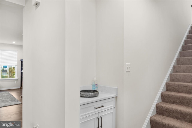 stairs with recessed lighting, baseboards, and wood finished floors