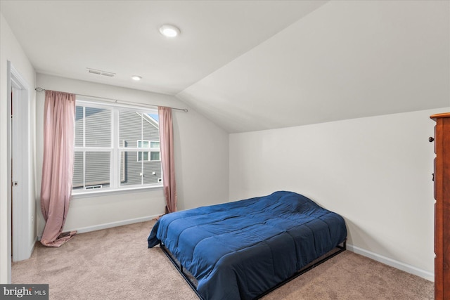 carpeted bedroom with lofted ceiling, baseboards, and visible vents