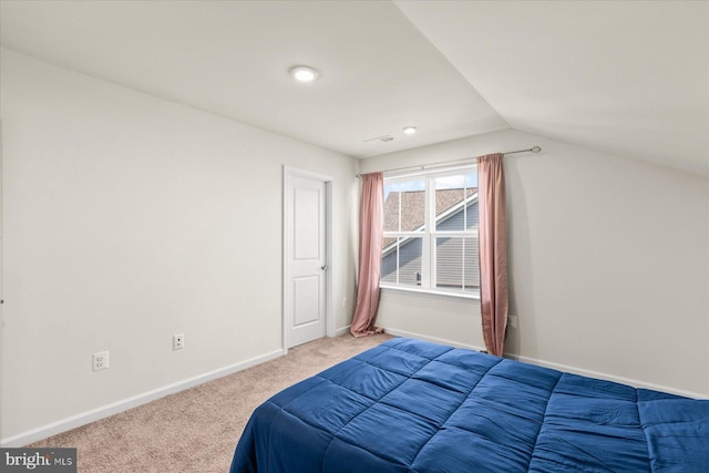 carpeted bedroom featuring vaulted ceiling and baseboards