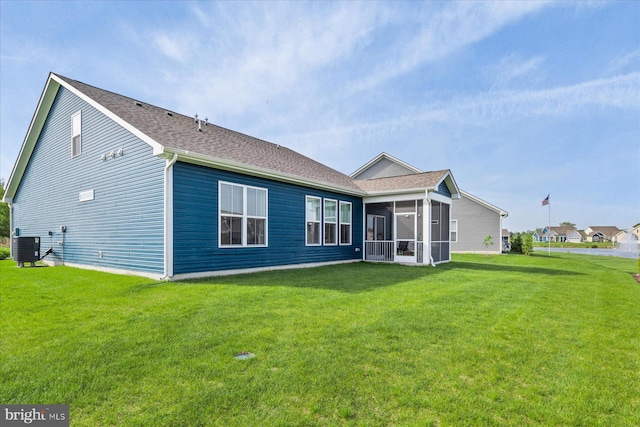 back of house featuring a sunroom, central AC, and a lawn