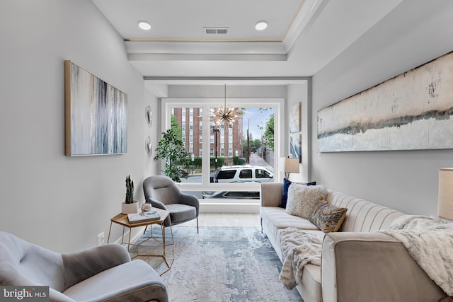 living room featuring visible vents, wood finished floors, and an inviting chandelier