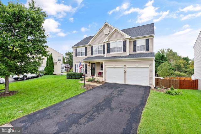 view of front of house with fence, driveway, a front yard, and a garage
