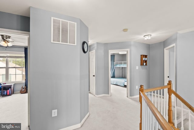 hall featuring light colored carpet, baseboards, visible vents, and an upstairs landing