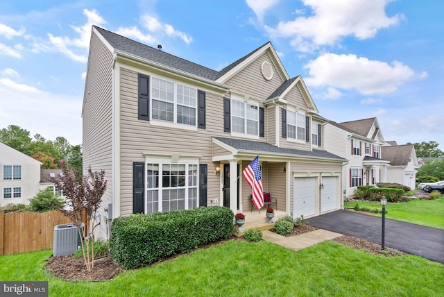 traditional home featuring fence, central AC, aphalt driveway, a garage, and a front yard
