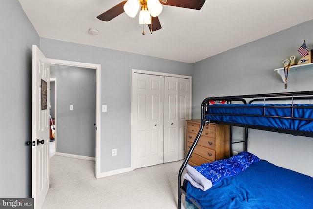 carpeted bedroom featuring baseboards, a ceiling fan, and a closet