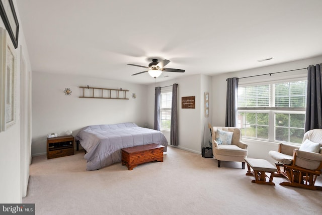 carpeted bedroom with visible vents, baseboards, and ceiling fan