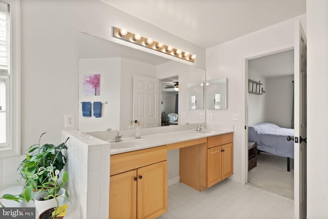 ensuite bathroom featuring ensuite bathroom, a sink, tile patterned floors, and double vanity