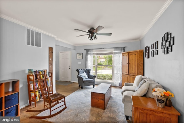 living area with visible vents, ornamental molding, a ceiling fan, and wood finished floors