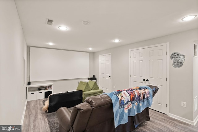 home theater room with visible vents, recessed lighting, baseboards, and wood finished floors