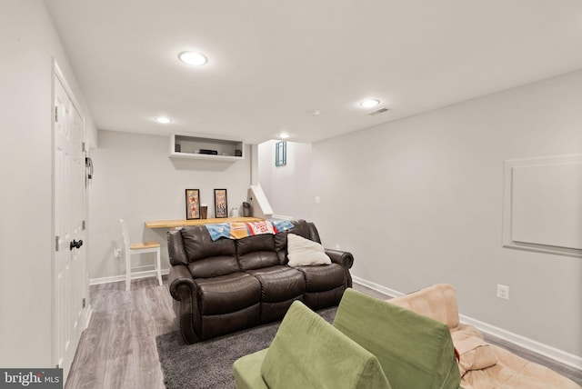 living room with recessed lighting, baseboards, wood finished floors, and visible vents