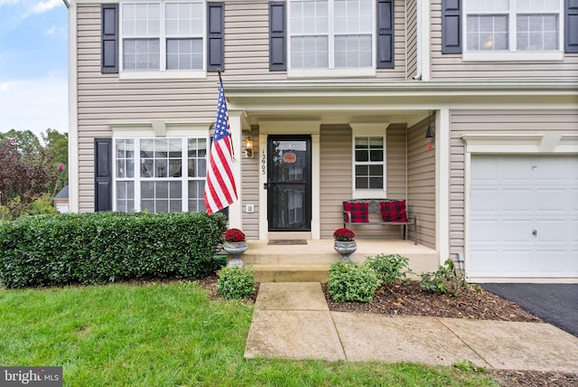 entrance to property featuring a porch and a garage