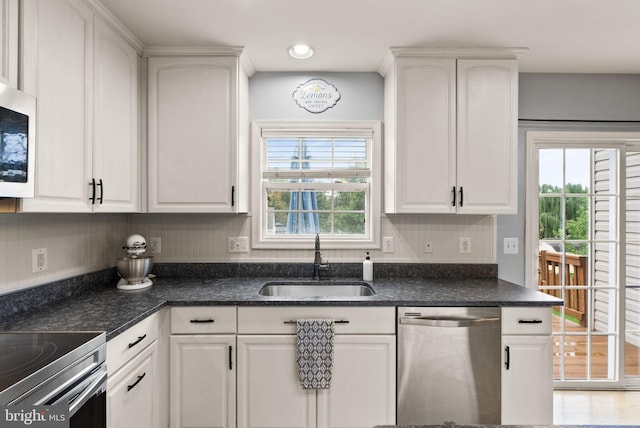 kitchen with a sink, appliances with stainless steel finishes, white cabinets, and recessed lighting