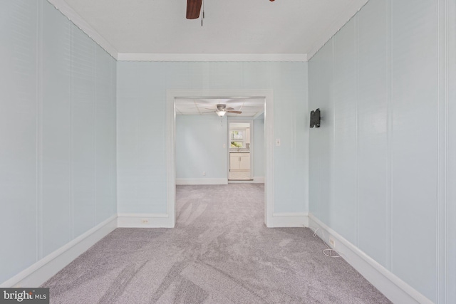 spare room with ceiling fan, carpet, ornamental molding, and baseboards