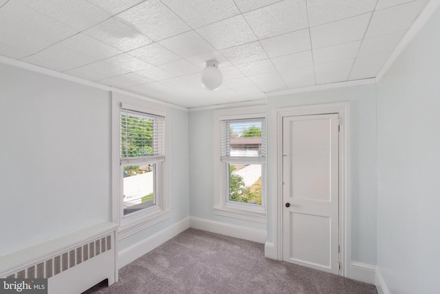 carpeted spare room featuring radiator, healthy amount of natural light, and baseboards