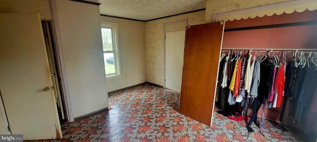 unfurnished bedroom with a closet, tile patterned floors, a textured ceiling, crown molding, and baseboards